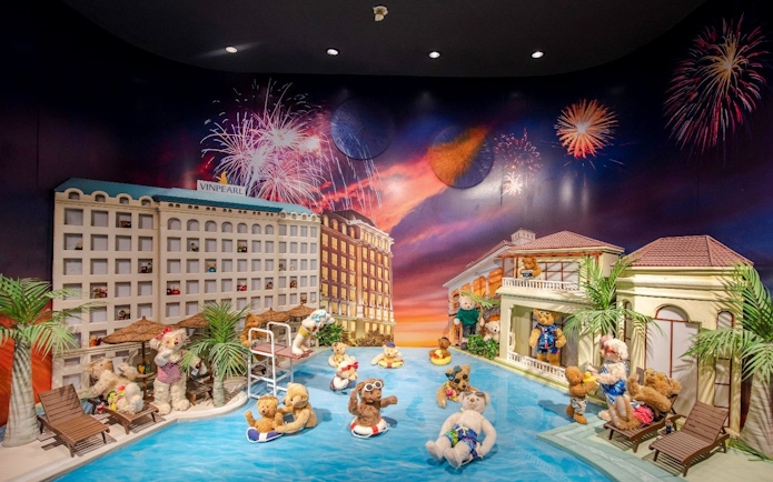 Teddy bears enjoying a pool scene with fireworks at the Teddy Bear Museum.