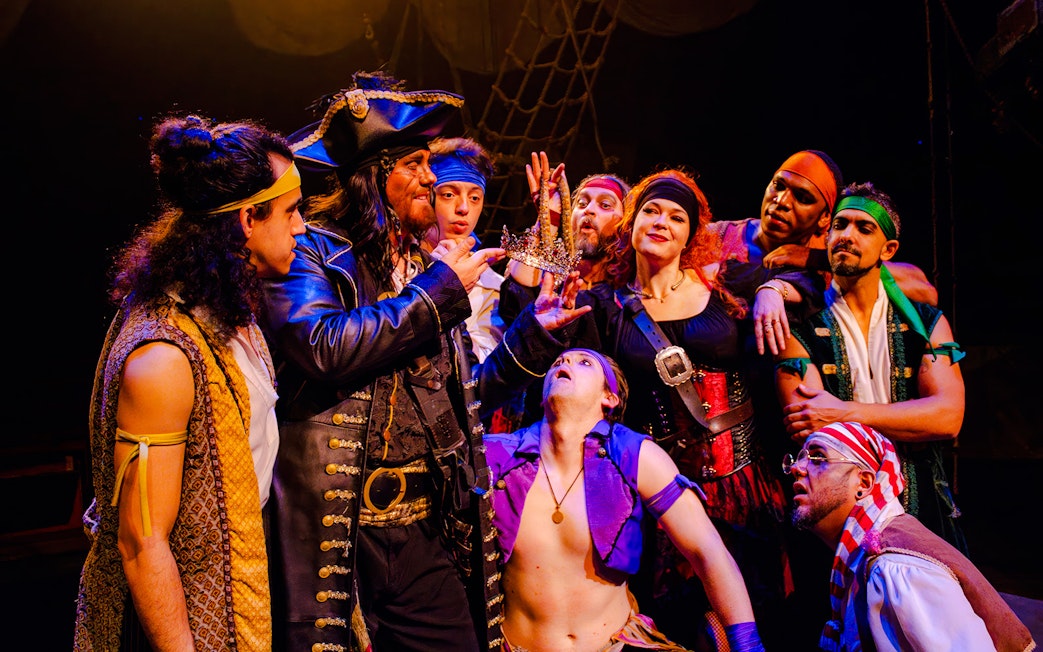 Pirates in costume holding a crown during the Pirates Dinner Adventure Show.