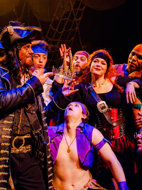 Pirates in costume holding a crown during the Pirates Dinner Adventure Show.