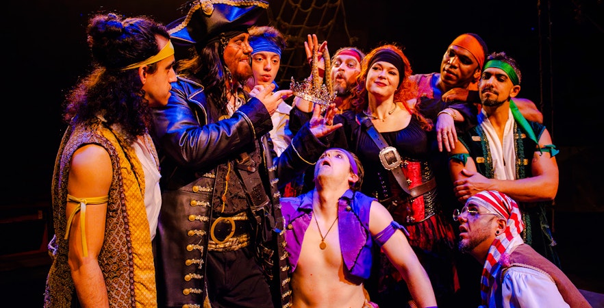 Pirates in costume holding a crown during the Pirates Dinner Adventure Show.