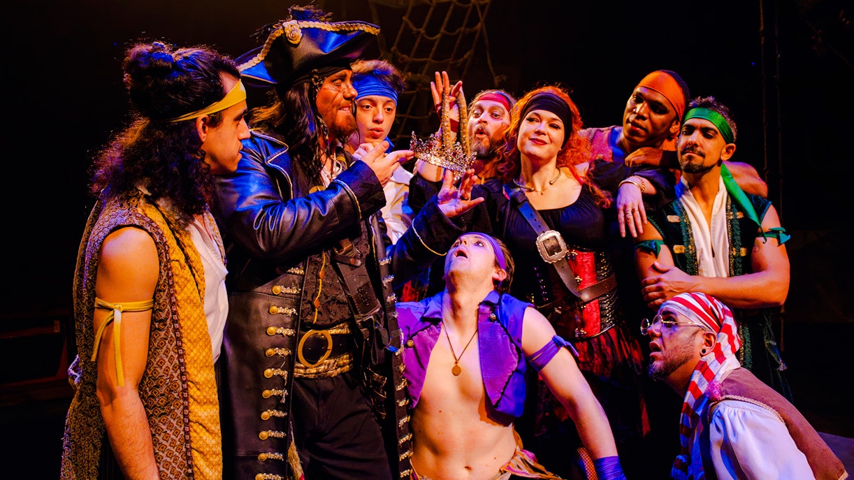 Pirates in costume holding a crown during the Pirates Dinner Adventure Show.