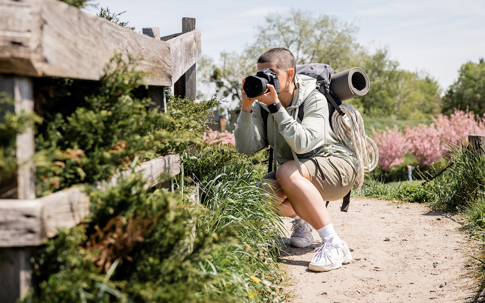 Person photographing nature on a trail near Blue Planet Aquarium.