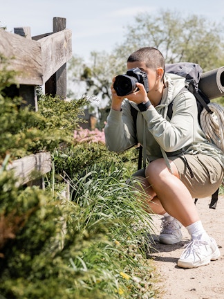 Person photographing nature on a trail near Blue Planet Aquarium.