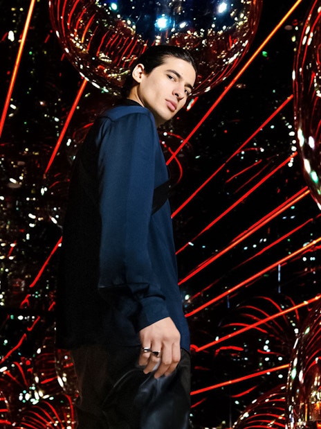 Person standing in a reflective room with red lights at AYA Universe.