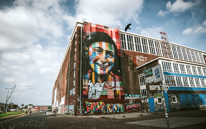 STRAAT Museum mural on a brick building in Amsterdam with street art and graffiti.