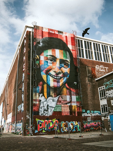 STRAAT Museum mural on a brick building in Amsterdam with street art and graffiti.