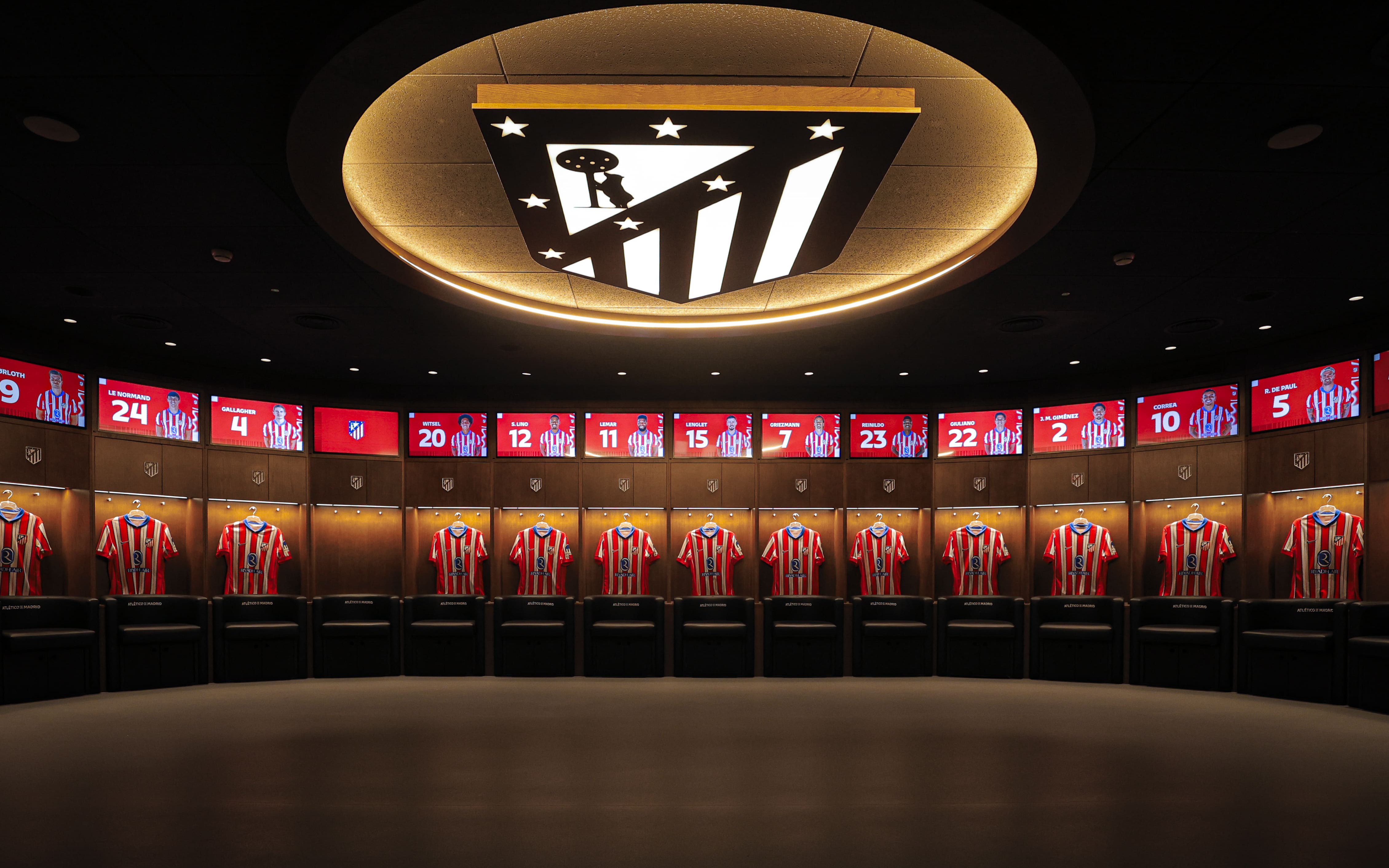 Atletico de Madrid Stadium players dressing room with jerseys displayed.