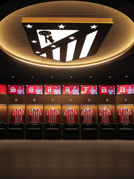 Atletico de Madrid Stadium players dressing room with jerseys displayed.