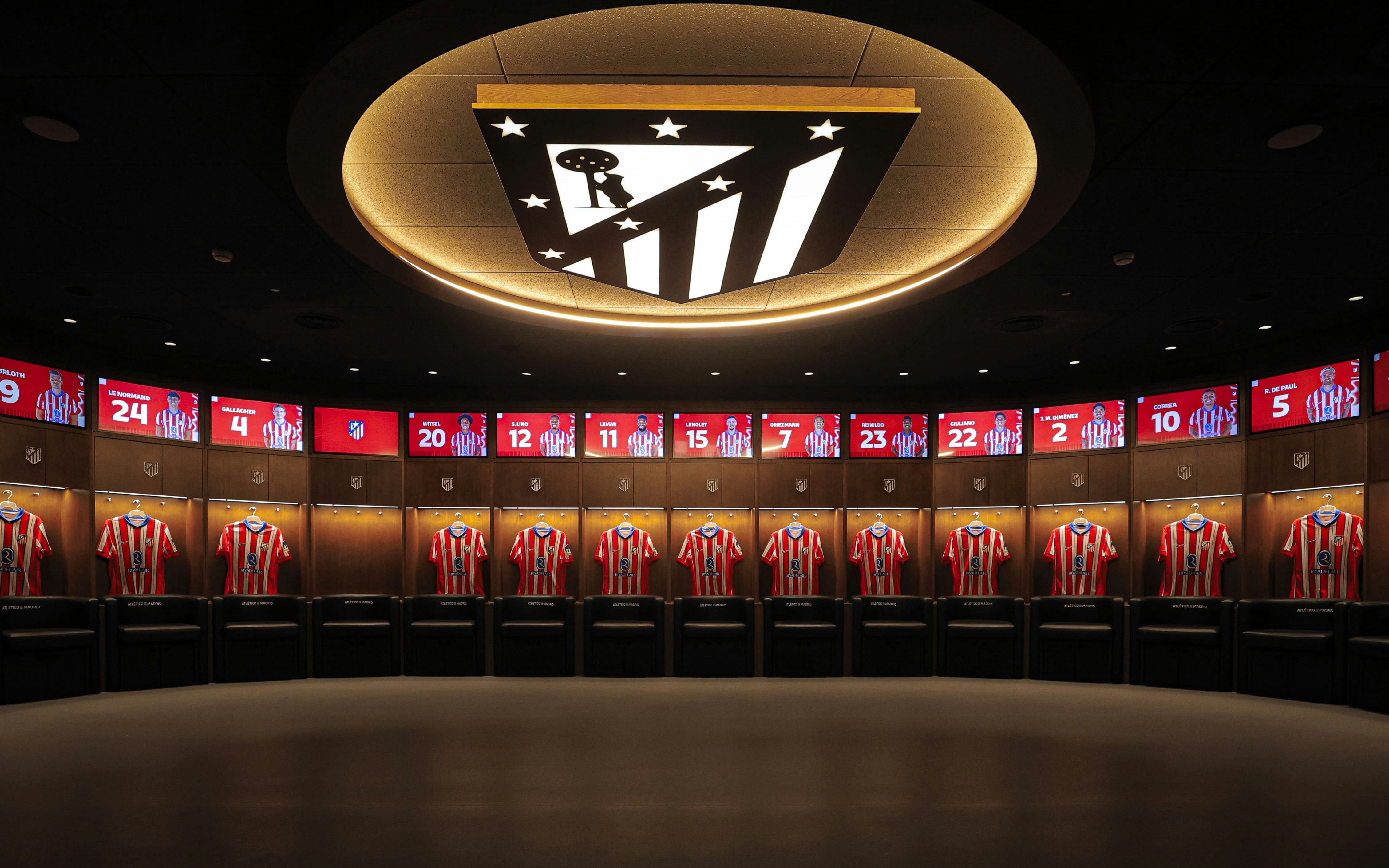 Atletico de Madrid Stadium players dressing room with jerseys displayed.