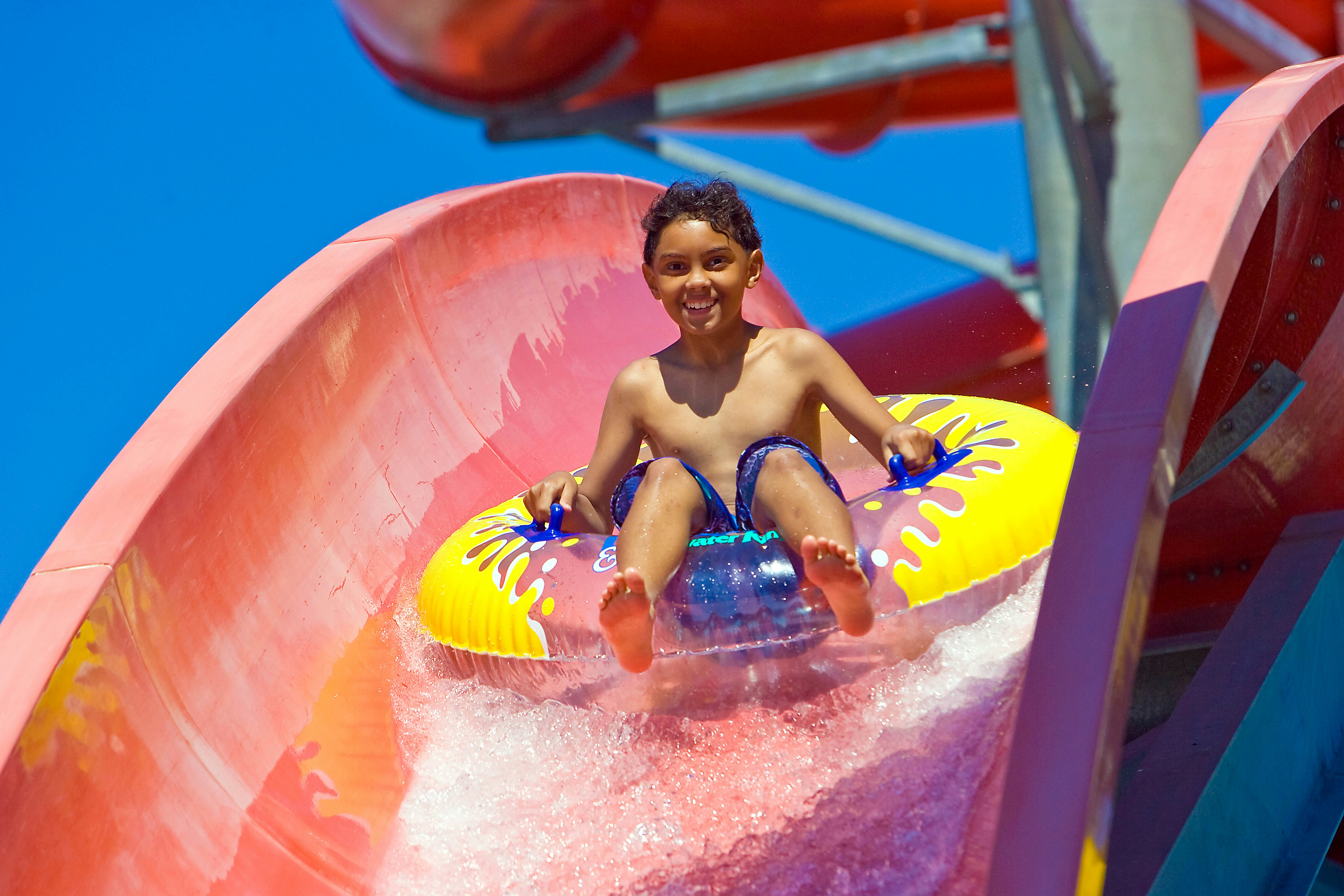 Child enjoying water slide at Lightning Falls, Hurricane Harbor Los Angeles, Six Flags.
