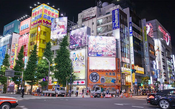 Akihabara City at night with illuminated buildings and colorful billboards.