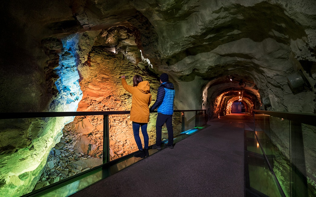 Visitors exploring illuminated tunnel at Jungfraujoch, Switzerland.