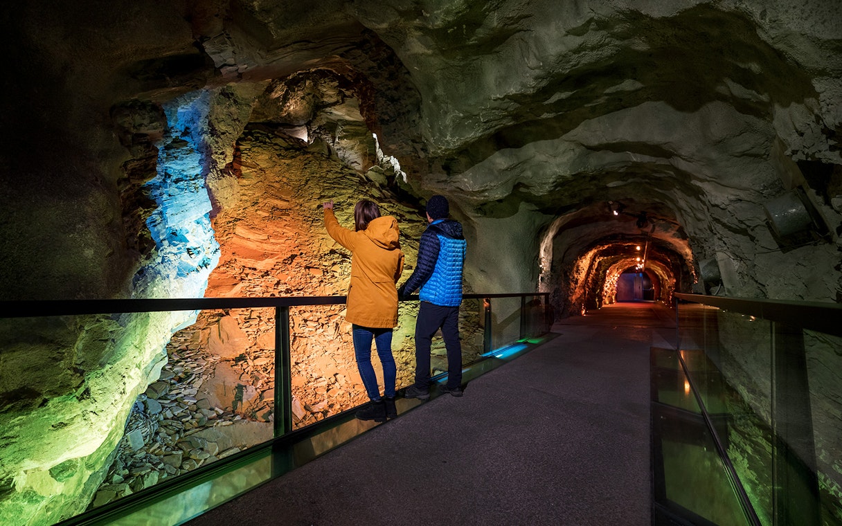 Visitors exploring illuminated tunnel at Jungfraujoch, Switzerland.