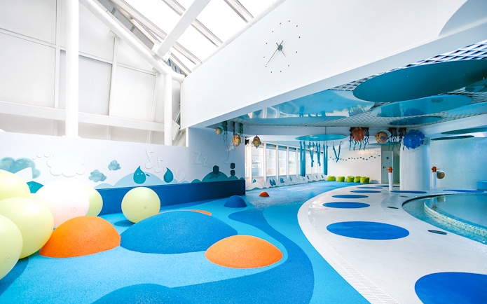 Indoor play area with colorful padded mounds and wall art at Caldea spa, Andorra.