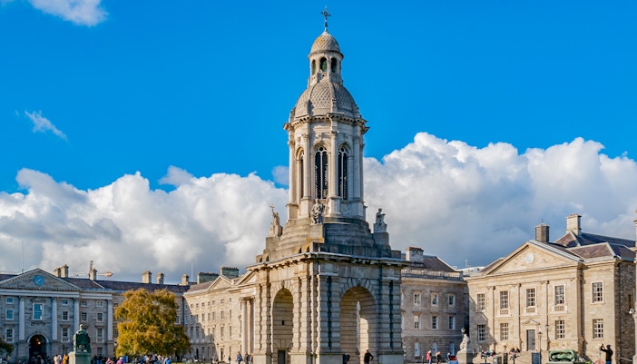 Trinity College Campanile with tourists exploring the historic Dublin campus.