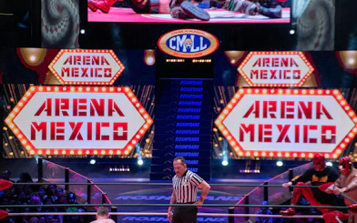 Wrestling match at Arena Mexico with luchadores and referee in the ring.
