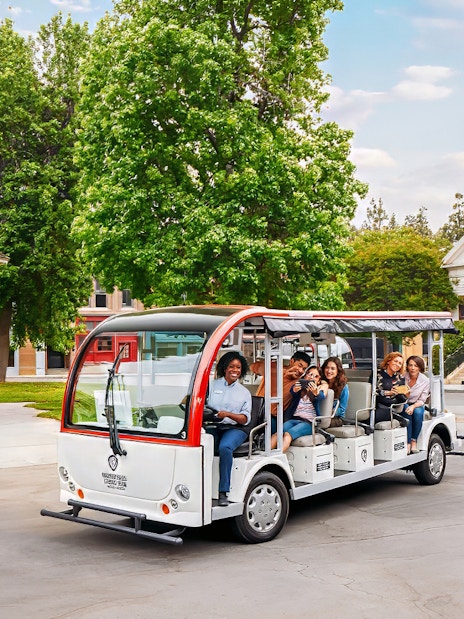 Tourists on a tram at Warner Bros. Studio, Los Angeles, with film set backdrop.