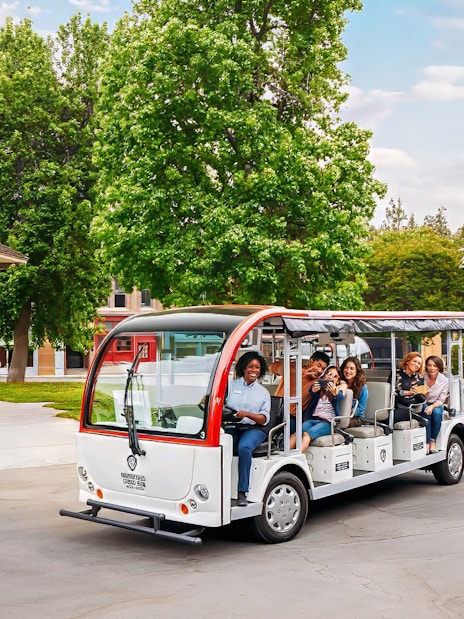 Tourists on a tram at Warner Bros. Studio, Los Angeles, with film set backdrop.