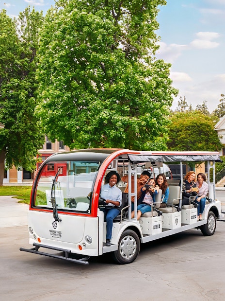 Tourists on a tram at Warner Bros. Studio, Los Angeles, with film set backdrop.