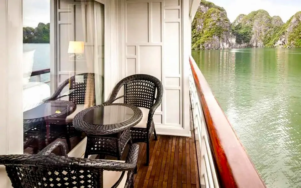 Deluxe cabin balcony overlooking Ha Long Bay on 5-star premium cruise.
