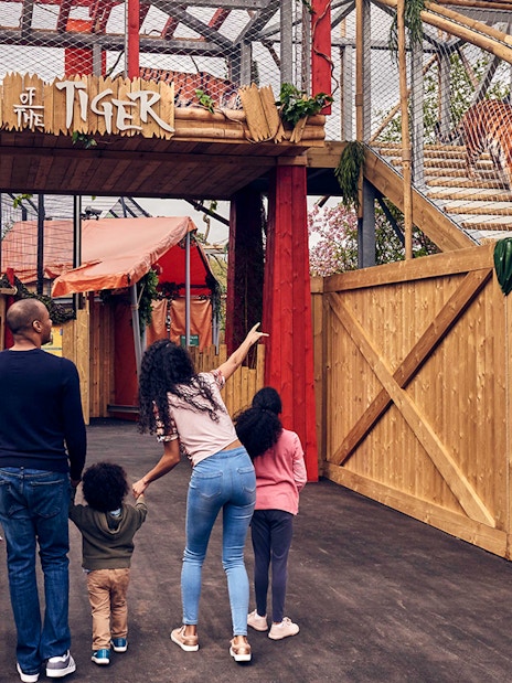 Family observing a tiger in the Land of the Tiger enclosure at Chessington Zoo.