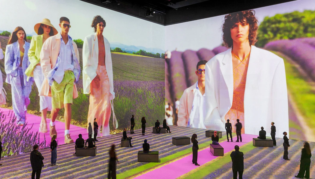 Fashion show projection with models walking on a lavender field runway at Vogue: Inventing the Runway event.