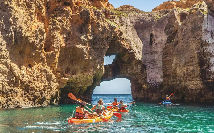 Kayakers exploring sea caves at Ponta da Piedade, Algarve.