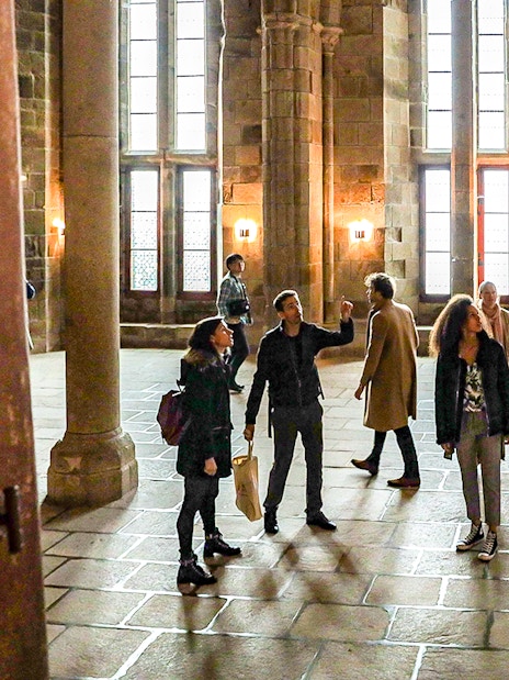 Visitors with a guide exploring the interior of Mont Saint-Michel Abbey.