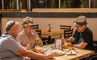 Group enjoying local food and drinks at a Bucharest restaurant during a cultural walking tour.