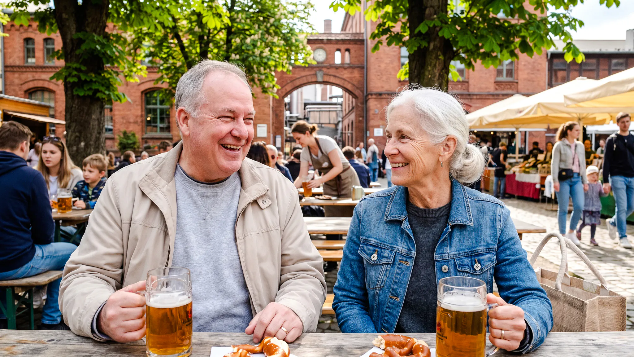 Couple enjoying beer and pretzels at an outdoor table during Berlin Oktoberfest walking tour.