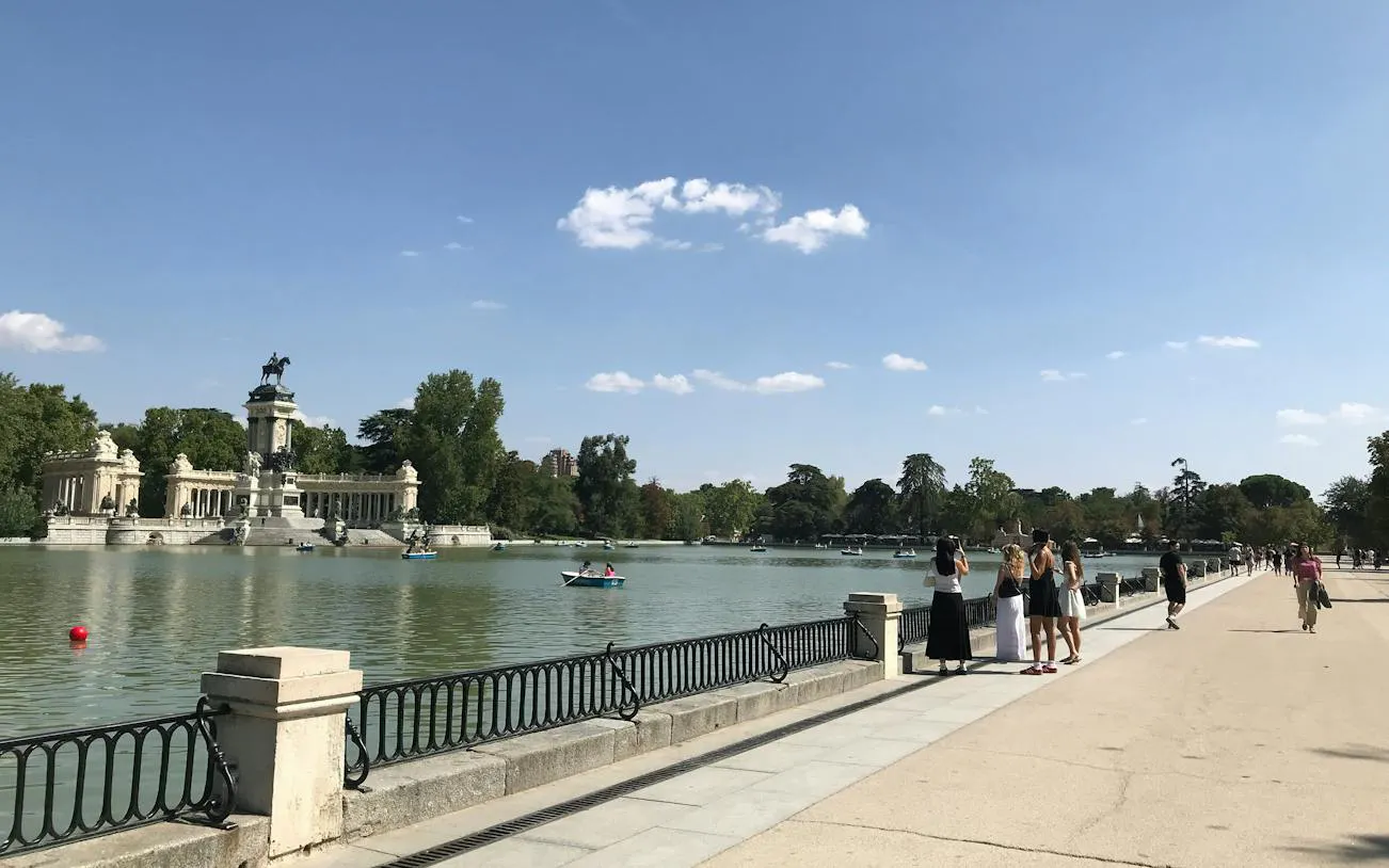 Retiro Park lake with monument and people enjoying a sunny day, Madrid.