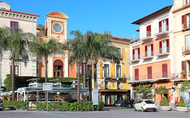 Tasso Square in Sorrento with clock tower and colorful buildings.