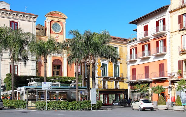 Tasso Square in Sorrento with clock tower and colorful buildings.