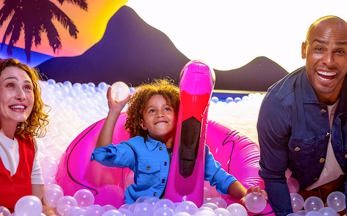 Guests playing in a ball pit at Dopamine Land with inflatable flamingo.
