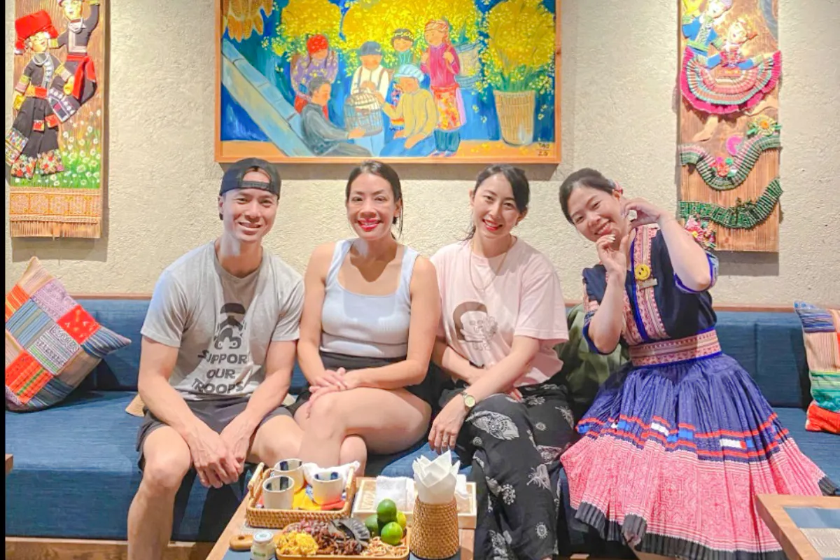 Group enjoying relaxation at Herbal Spa, Da Nang, with colorful artwork in the background.