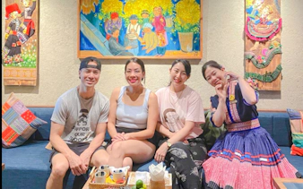 Group enjoying relaxation at Herbal Spa, Da Nang, with colorful artwork in the background.
