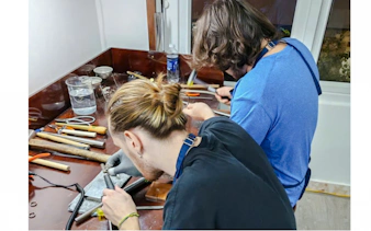 Participants crafting silver jewelry in a workshop with tools in Da Nang.