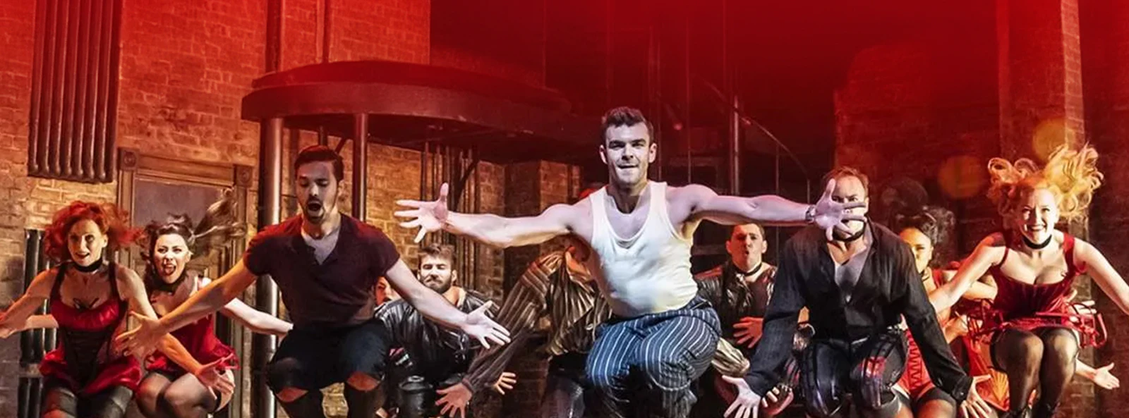 Performers dancing energetically on stage in "Kiss Me, Kate" musical.