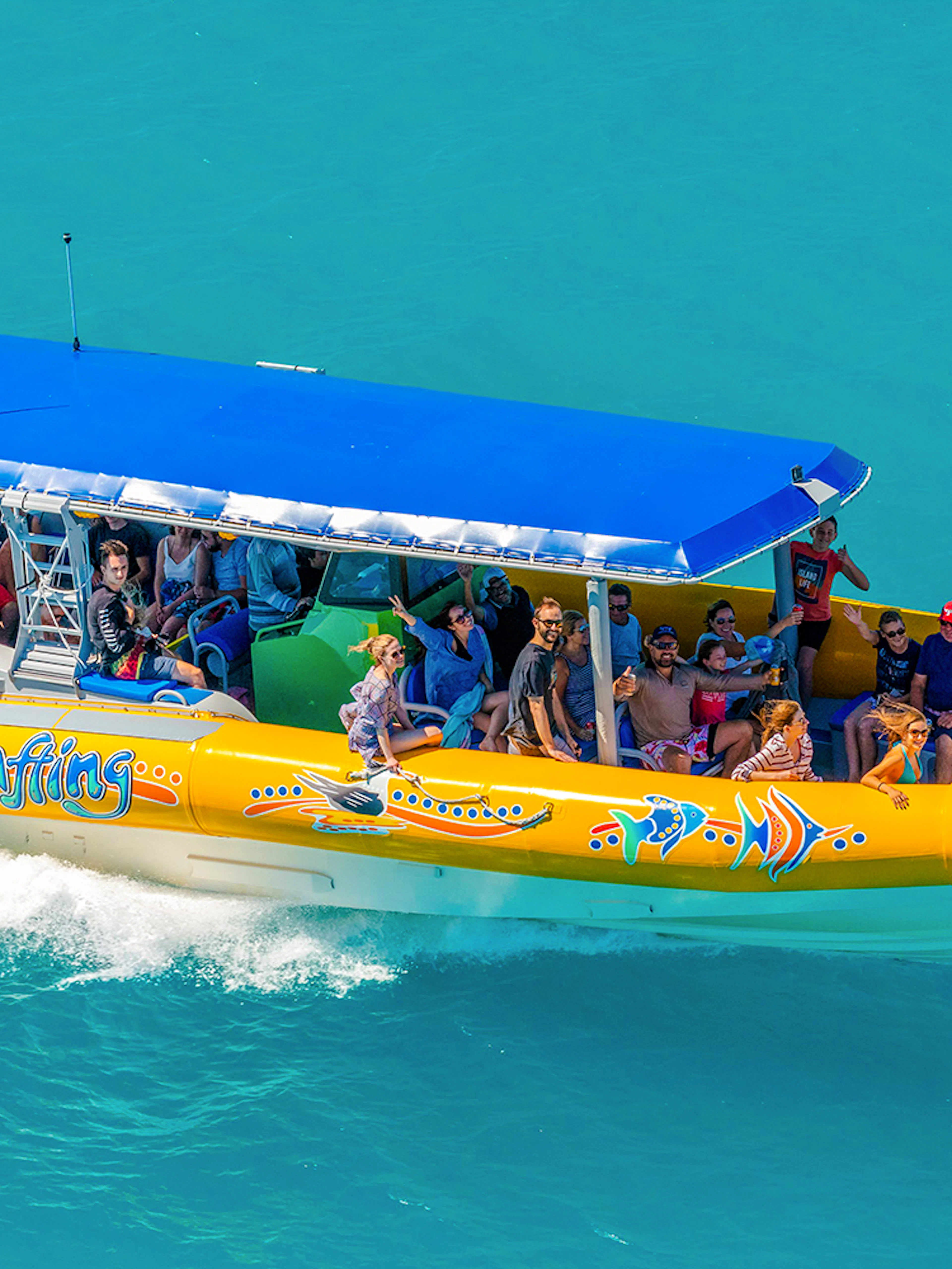 Snorkel cruise boat with tourists on turquoise water near Airlie Beach, Whitsundays.
