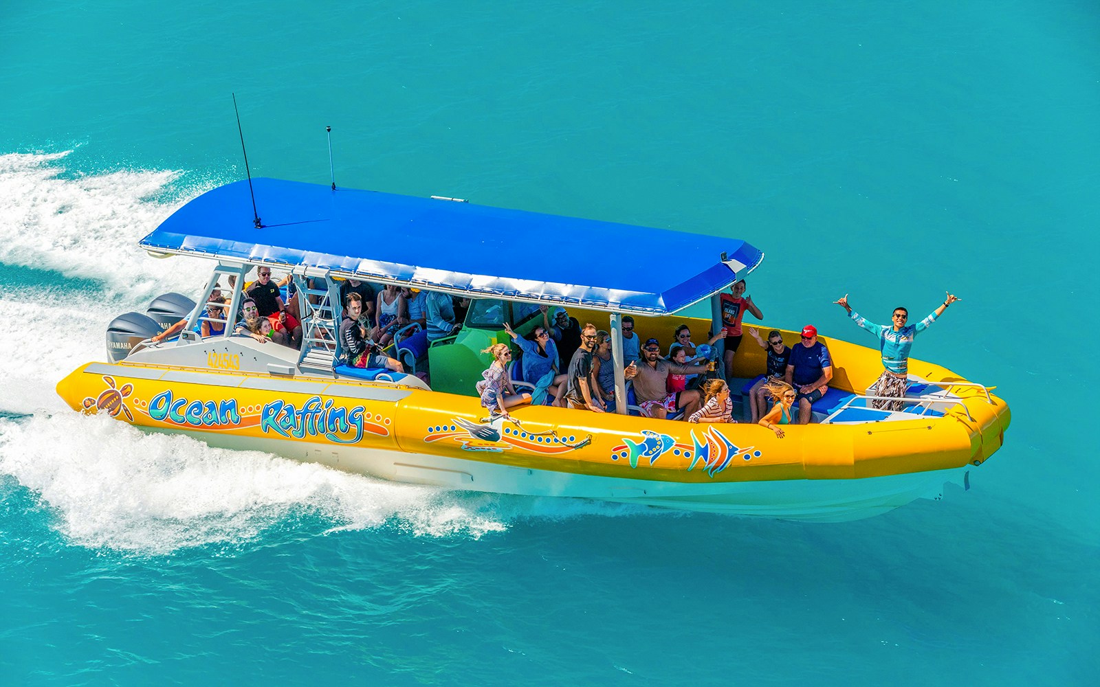 Snorkel cruise boat with tourists on turquoise water near Airlie Beach, Whitsundays.
