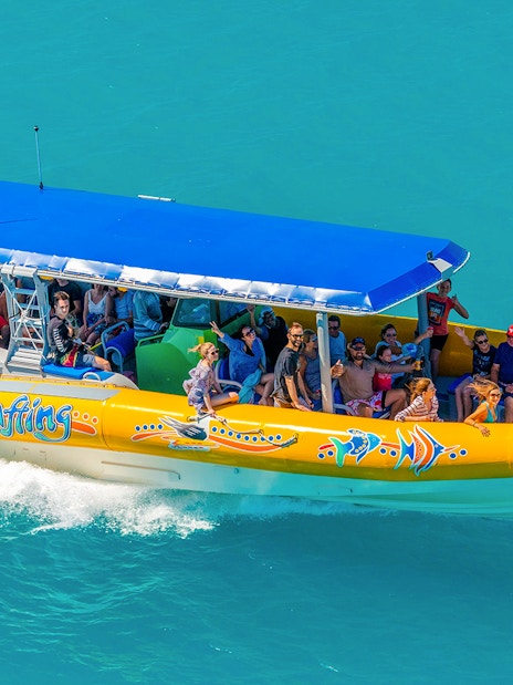 Snorkel cruise boat with tourists on turquoise water near Airlie Beach, Whitsundays.