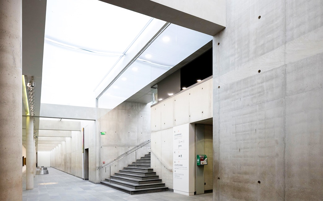 Orangerie Museum interior with modern concrete walls and staircase.