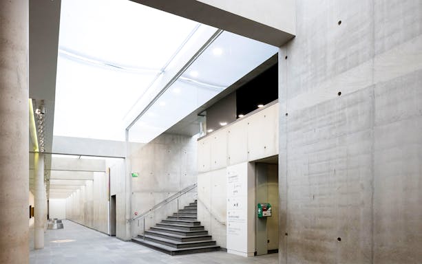 Orangerie Museum interior with modern concrete walls and staircase.