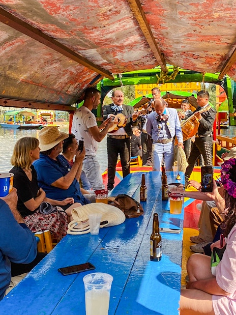 Mariachi band performing on a colorful boat during a Xochimilco tour in Mexico City.
