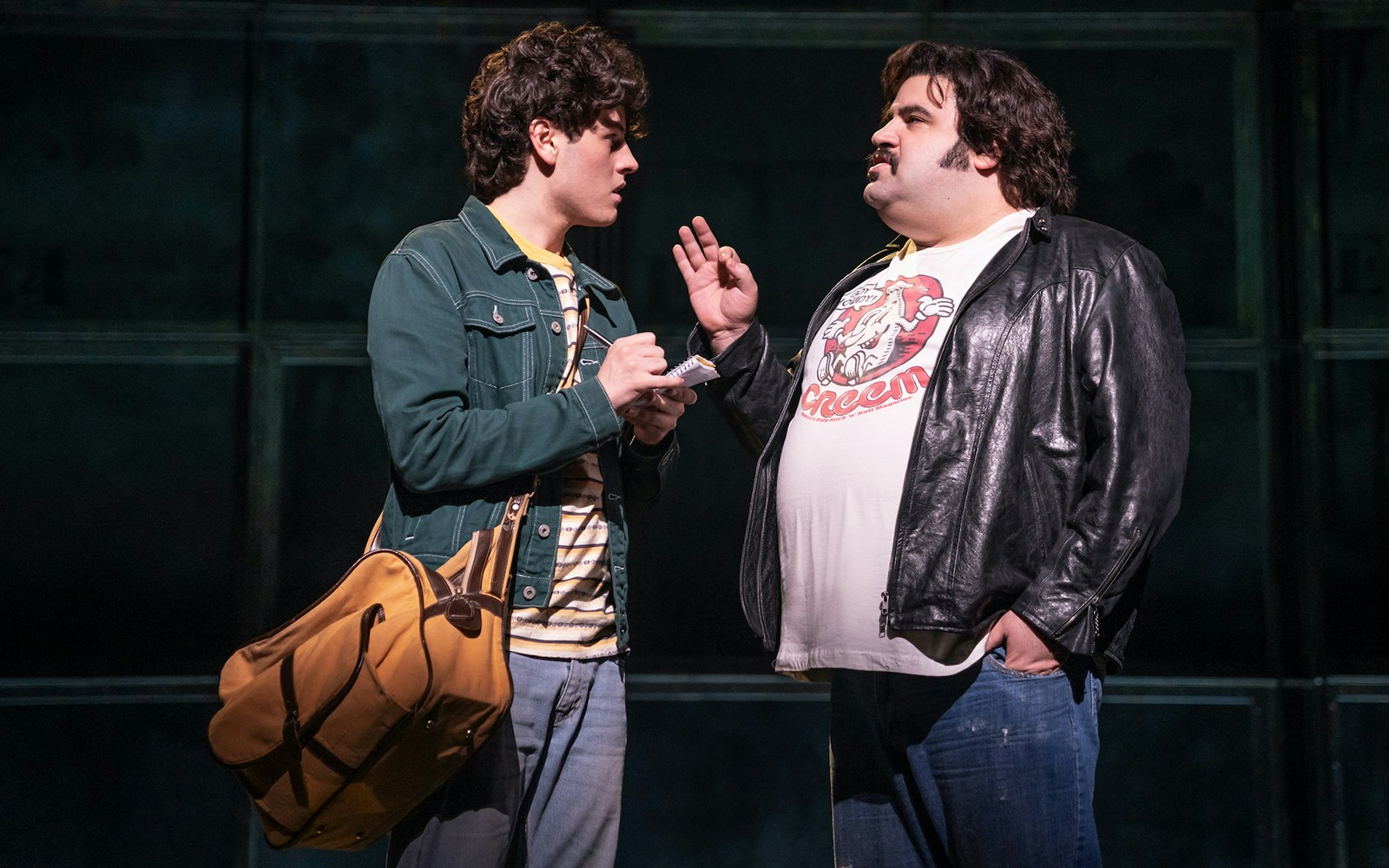 Two actors in a scene from the musical "Almost Famous" on stage.