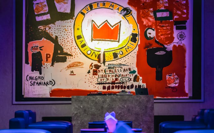 Graffiti art by Jean-Michel Basquiat featuring a crown motif at Behind the Canvas Series 1.