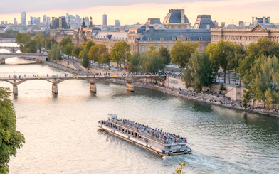 Seine River cruise boat passing by the Louvre Museum in Paris.