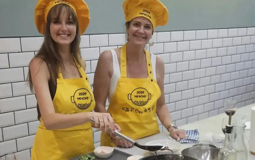 Participants in a cooking class preparing paella in Barcelona kitchen.