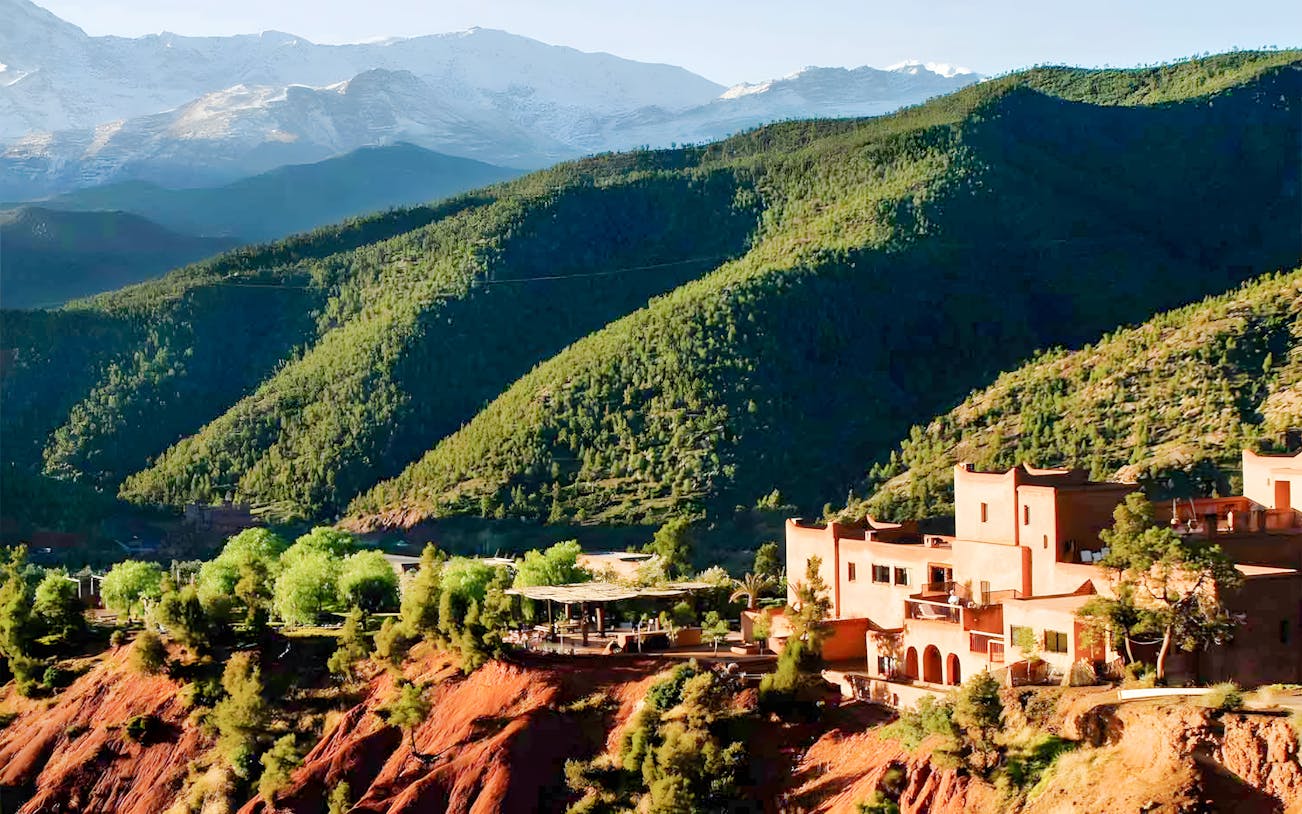 Ourika Valley landscape with traditional buildings and lush green hills.