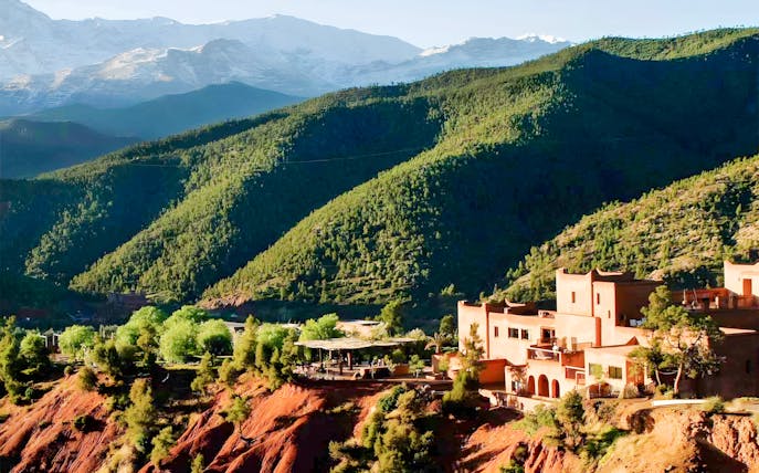 Ourika Valley landscape with traditional buildings and lush green hills.